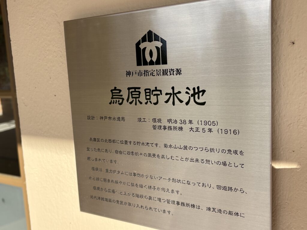 「神戸市指定景観資源 烏原貯水池」のプレート。堰堤だけでなく、管理事務所棟も烏原貯水池の景観資源を構成する要素として位置づけられている。