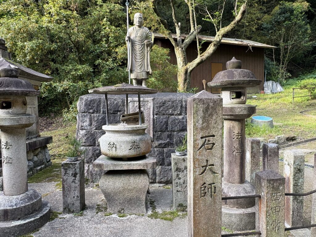 石垣寄進銘の後ろに並ぶ十三体の仏像。前列・中段・上段に分かれて祀られている。