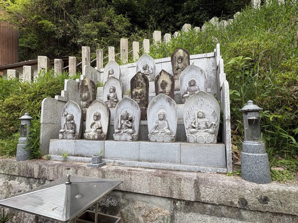 石垣寄進銘の後ろに並ぶ十三体の仏像。前列・中段・上段に分かれて祀られている。